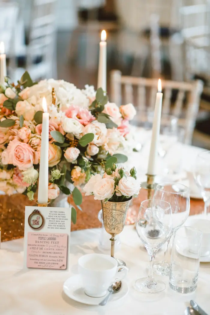 Peach roses and candles on a reception table.
